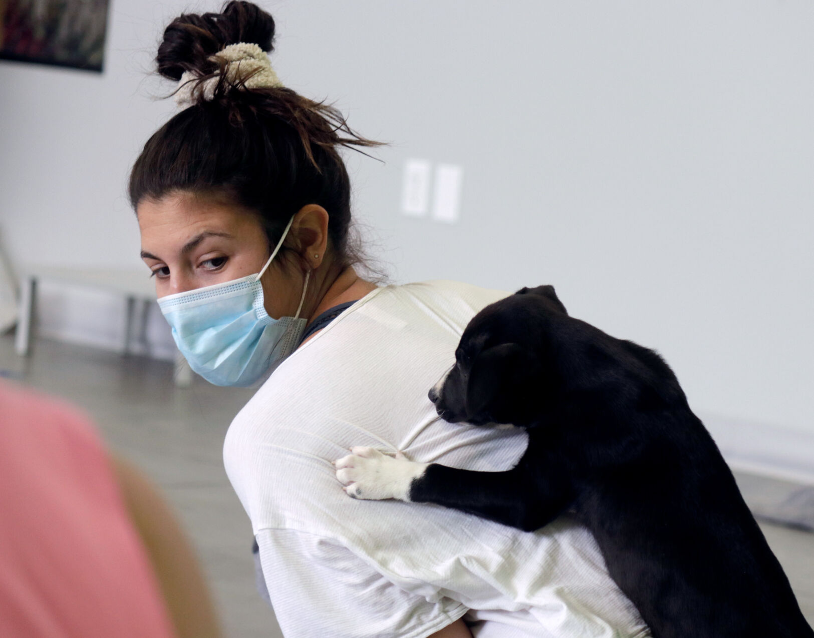 A puppy jumps on Rachel Buccieri during puppy yoga